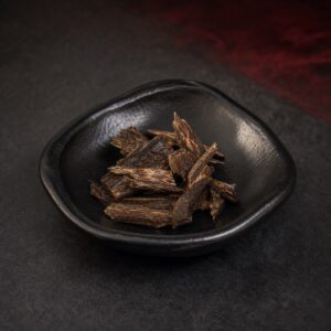 Twenty gram selection of resin-rich Sarawak agarwood chips in a black ceramic dish