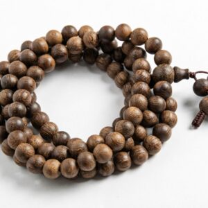 Guyun sinking-grade agarwood 108-bead mala laid in a full circle with guru bead and knotted cord