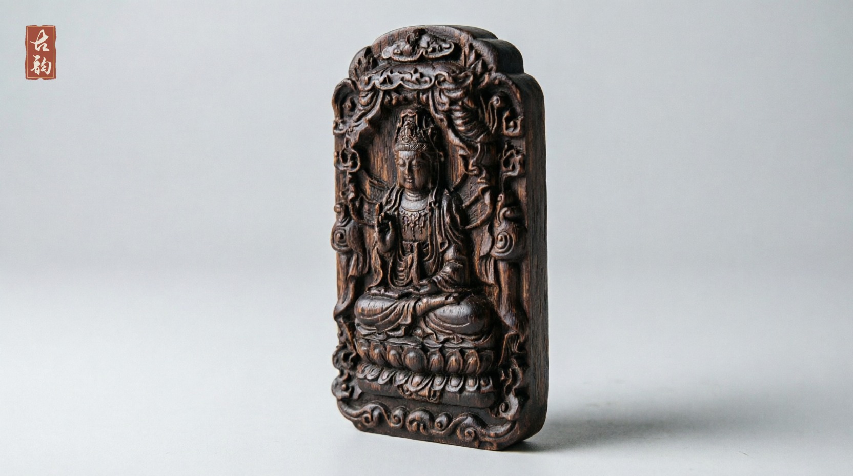 Guanyin agarwood amulet at an angle, showing the depth of the relief and the thickness of the block
