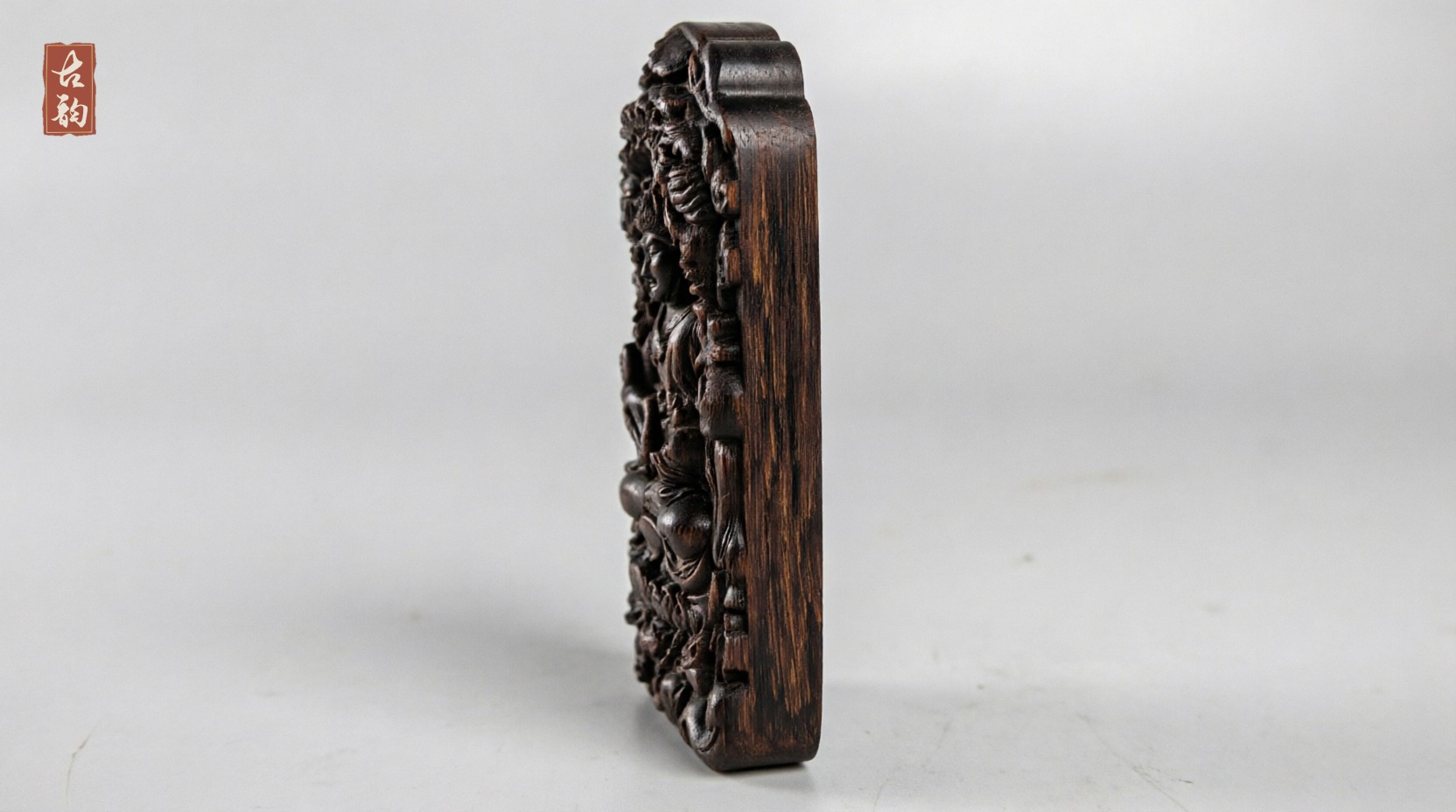 Edge profile of the Guanyin agarwood amulet, relief cut down into one solid block rather than applied